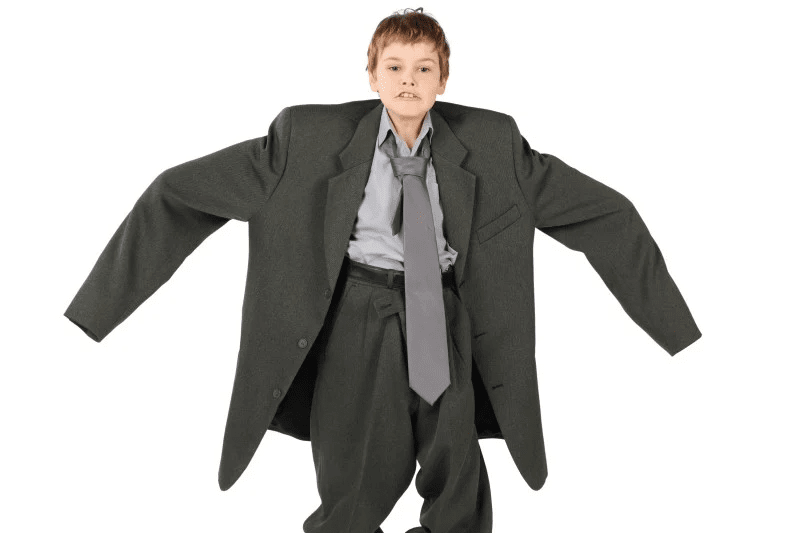 Un niño con un traje cuatro tallas más grande